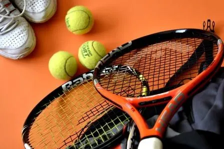 two tennis rackets and three balls
